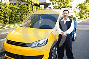 Portrait of smiling taxi driver with car