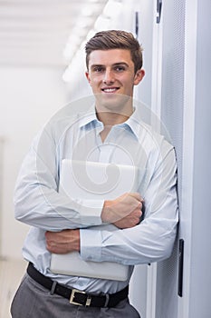 Portrait of a smiling technician holding a laptop