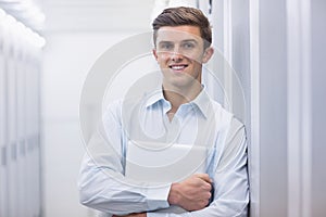 Portrait of a smiling technician holding a laptop