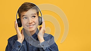 Portrait Of Smiling Teen Boy Listening Music In Wireless Headphones