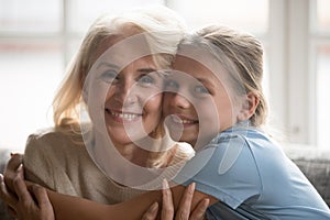 Portrait of smiling teen granddaughter hug senior granny