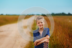 Portrait smiling Teenage boy with acoustic guitar on country road