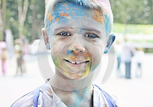 Portrait of a smiling teenage boy with multi-colored face at the