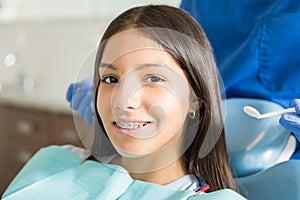 Portrait Of Smiling Teenage Girl With Braces In Clinic