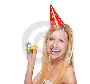 Portrait of smiling teenage girl in cap party horn blower