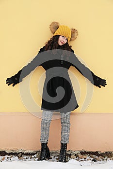 Portrait of smiling teenage girl in front of yellow wall