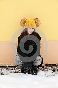 Portrait of smiling teenage girl in front of yellow wall