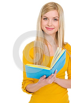 Portrait of smiling teenage student girl with book