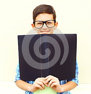 portrait smiling teenager boy in eyeglasses with folder or book