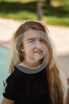 Portrait of a smiling teenager girl with long blonde hair