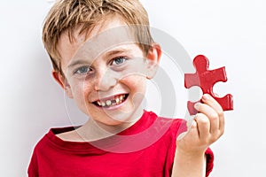 Smiling toothless boy finding special jigsaw for growing up idea photo