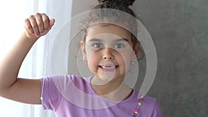 Portrait of a smiling toothless child holding a tooth on a string. Successful attempt to remove a tooth. Pull out the