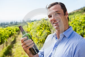 Portrait of smiling vintner examining wine