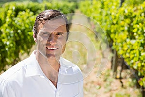 Portrait of smiling vintner standing in vineyard