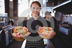 Portrait of smiling waitress serving fresh burgers at coffee shop