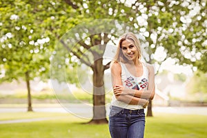Portrait of smiling woman with arms crossed while standing on grass