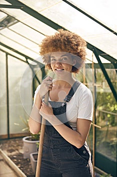 Portrait Of Smiling Woman With Broom Working In Greenhouse At Home