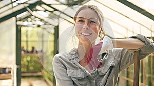 Portrait Of Smiling Woman With Broom Working In Greenhouse At Home