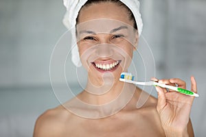 Portrait of smiling woman brush teeth in bathroom