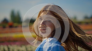 Portrait of smiling woman dancing. Flirty girl turning around in blloming park.