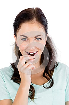 Portrait of smiling woman eating chocolate bar