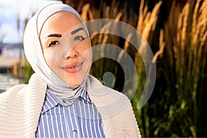 portrait of smiling woman in hijab. Beautiful nature of the Norwegian park