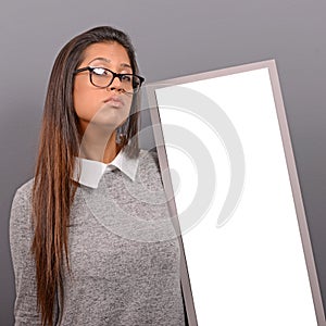 Portrait of smiling woman holding blank sign board.Studio portrait of young woman with sign card against gray background