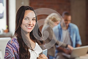 Portrait of smiling woman holding digital tablet in office
