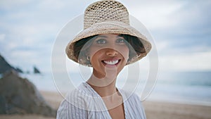 Portrait smiling woman looking camera on beach. Attractive travel girl at ocean