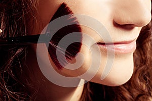 Portrait of smiling woman with make up tools