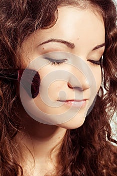 Portrait of smiling woman with make up tools