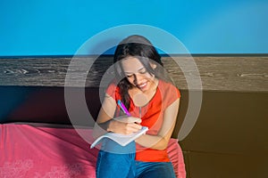 Portrait of a smiling woman making some notes in her diary related to her work. She has the inspiration