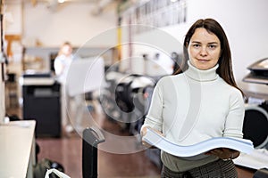 Portrait of smiling woman with ream of paper