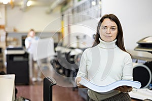 Portrait of smiling woman with ream of paper