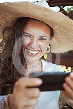 Portrait of smiling woman in shirt using smartphone app