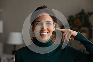 Portrait of smiling woman show point at face