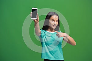 Portrait of a smiling woman showing blank smartphone screen