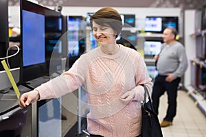 Portrait of a smiling woman standing in the department with televisions