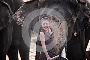 Portrait Of Smiling Woman Standing With Elephant In Thailand