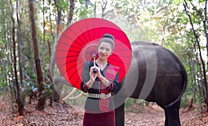 Portrait Of Smiling Woman Standing With Elephant In Thailand