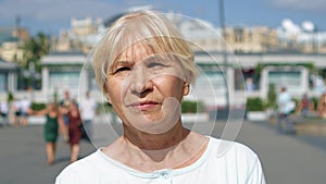 Portrait of smiling woman standing outdoors looking at camera. Pensioner traveling in Moscow, Russia