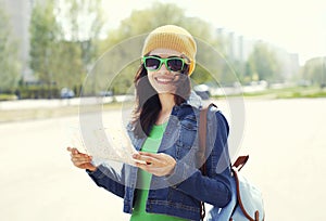 Portrait of smiling woman tourist sightseeing city with map