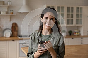 Portrait of smiling woman use smartphone at home