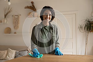 Portrait of smiling woman wipe dust from furniture