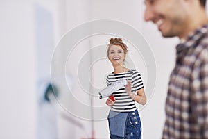 Portrait of smiling woman painting walls in her new home photo