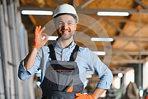 Portrait of smiling worker standing by industrial production machine.