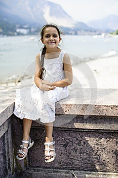 Portrait of a 7 year old girl sitting on a wall