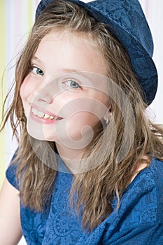 Portrait of a smiling 8 year old girl in a hat.