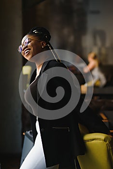 Portrait of a smiling young African American woman standing in front of her cafe with her arms crossed