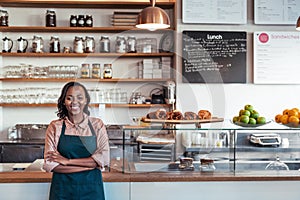 Smiling young African entrepreneur standing at her bakery counter photo